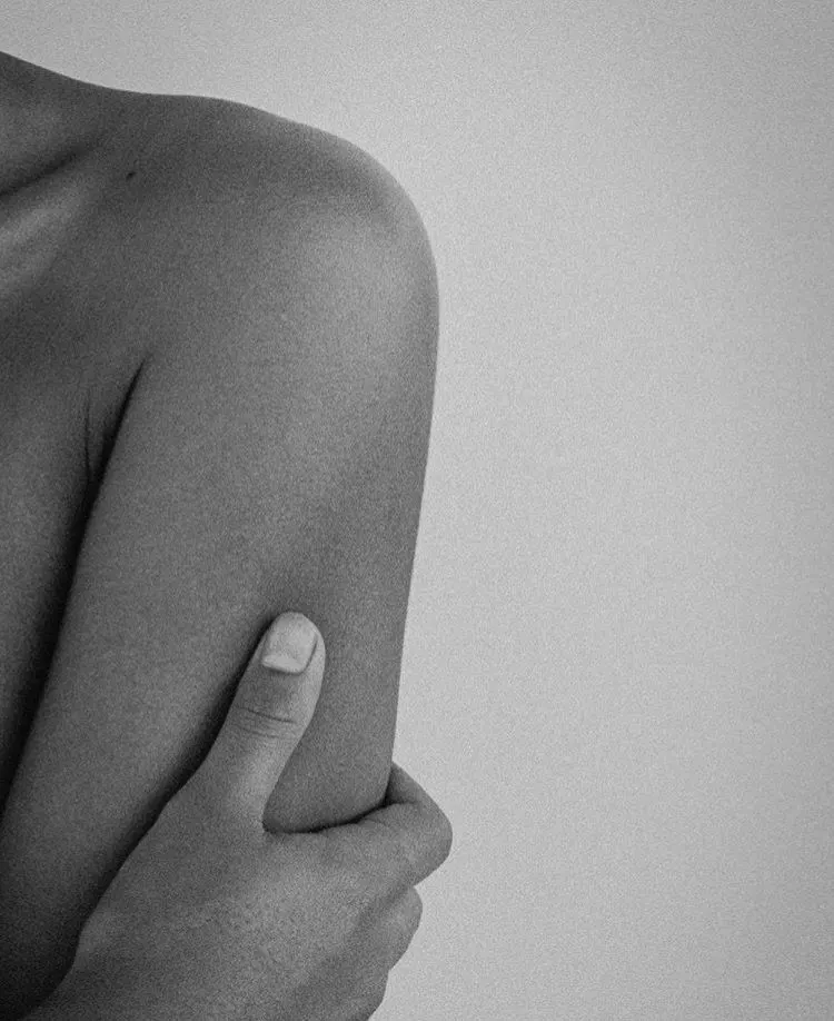 Retrato en blanco y negro de un brazo abrazando el cuerpo